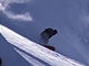 Snowboardista v terénu, v pozadí lavina