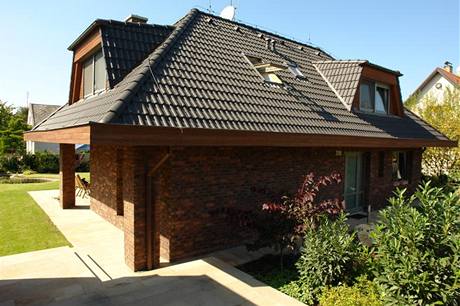 Charakteristickým znakem domů architekta Jiřího Houši je přesahující valbová střecha s výraznými lichoběžníkovými vikýři a obezdívka z režných cihel Charakteristickým znakem domů architekta Jiřího Houši je přesahující valbová střecha s výraznými lichoběžníkovými vikýři a obezdívka z režných cihel