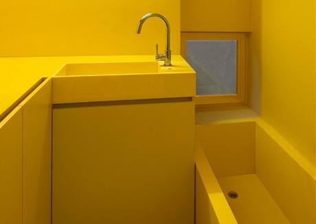 Stěny v koupelně jsou vymalovány omyvatelnou barvou ve žlutém odstínu. Vana je z moderního materiálu Corian Stěny v koupelně jsou vymalovány omyvatelnou barvou ve žlutém odstínu. Vana je z moderního materiálu Corian