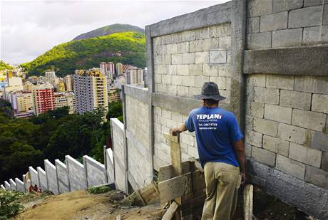Dělníci dokončují zeď kolem čtvrti Favela Santa Marta v brazilském Rio de Janeiru. Měla by zabránit expanzi nových staveb do chráněného deštného pralesa za hranicí města. Dělníci dokončují zeď kolem čtvrti Favela Santa Marta v brazilském Rio de Janeiru. Měla by zabránit expanzi nových staveb do chráněného deštného pralesa za hranicí města.