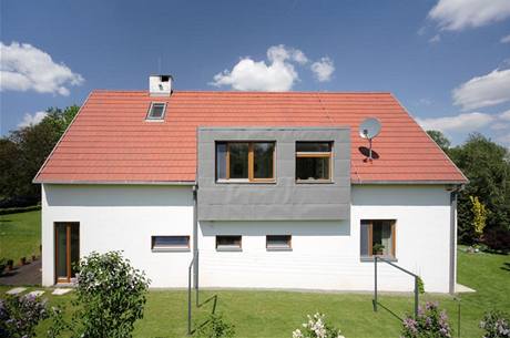 Do domu tradičního „venkovského“ tvaru se sedlovou střechou architekti zakomponovali moderní předsazený vikýř, obložený titanzinkovým plechem Do domu tradičního „venkovského“ tvaru se sedlovou střechou architekti zakomponovali moderní předsazený vikýř, obložený titanzinkovým plechem