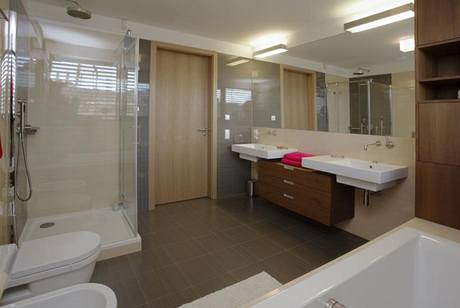 Do koupelny, vybavené elegantní italskou sanitární keramikou, navrhli sestavu skříněk s teakovou dýhou Do koupelny, vybavené elegantní italskou sanitární keramikou, navrhli sestavu skříněk s teakovou dýhou