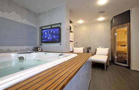 Jedna z koupelen slouží jako domácí lázně: masážní vana Persea (USSPA) pro 5 osob, sauna (Villeroy & Boch) a všudypřítomné televizní obrazovky Jedna z koupelen slouží jako domácí lázně: masážní vana Persea (USSPA) pro 5 osob, sauna (Villeroy & Boch) a všudypřítomné televizní obrazovky