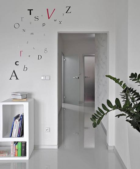 Lesklá podlaha vytváří zajímavý zrcadlový efekt. Bílé stěny jsou dekorovány tapetami (Lars Kontzen) a nálepkami ve tvaru písmen (Wise Decor) Lesklá podlaha vytváří zajímavý zrcadlový efekt. Bílé stěny jsou dekorovány tapetami (Lars Kontzen) a nálepkami ve tvaru písmen (Wise Decor)