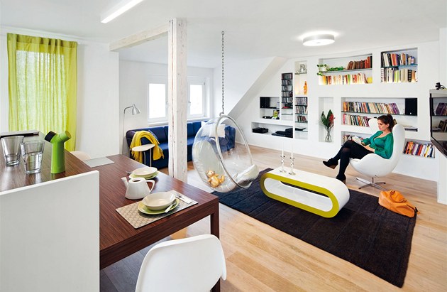 Obývací pokoj spojený s kuchyní a jídelním koutem ve spodní části bytu. Stěna z