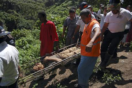 Záchranáři odnášejí jedno z těl, které se jim podařilo vyprostit zpod odpadků. (25. července 2008)
