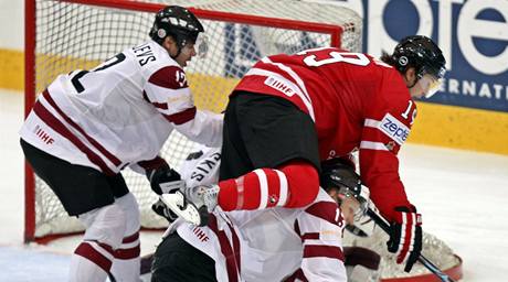 Kanada - Lotyšsko: Kanadský útočník Shane Doan padá přes Lotyše Guntise Galvinše, vlevo Herberts Vasiljevs.
